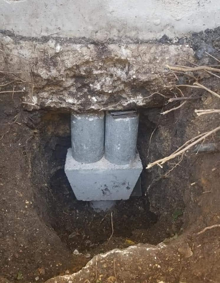 Concrete pier cylinders installed beneath a residential foundation